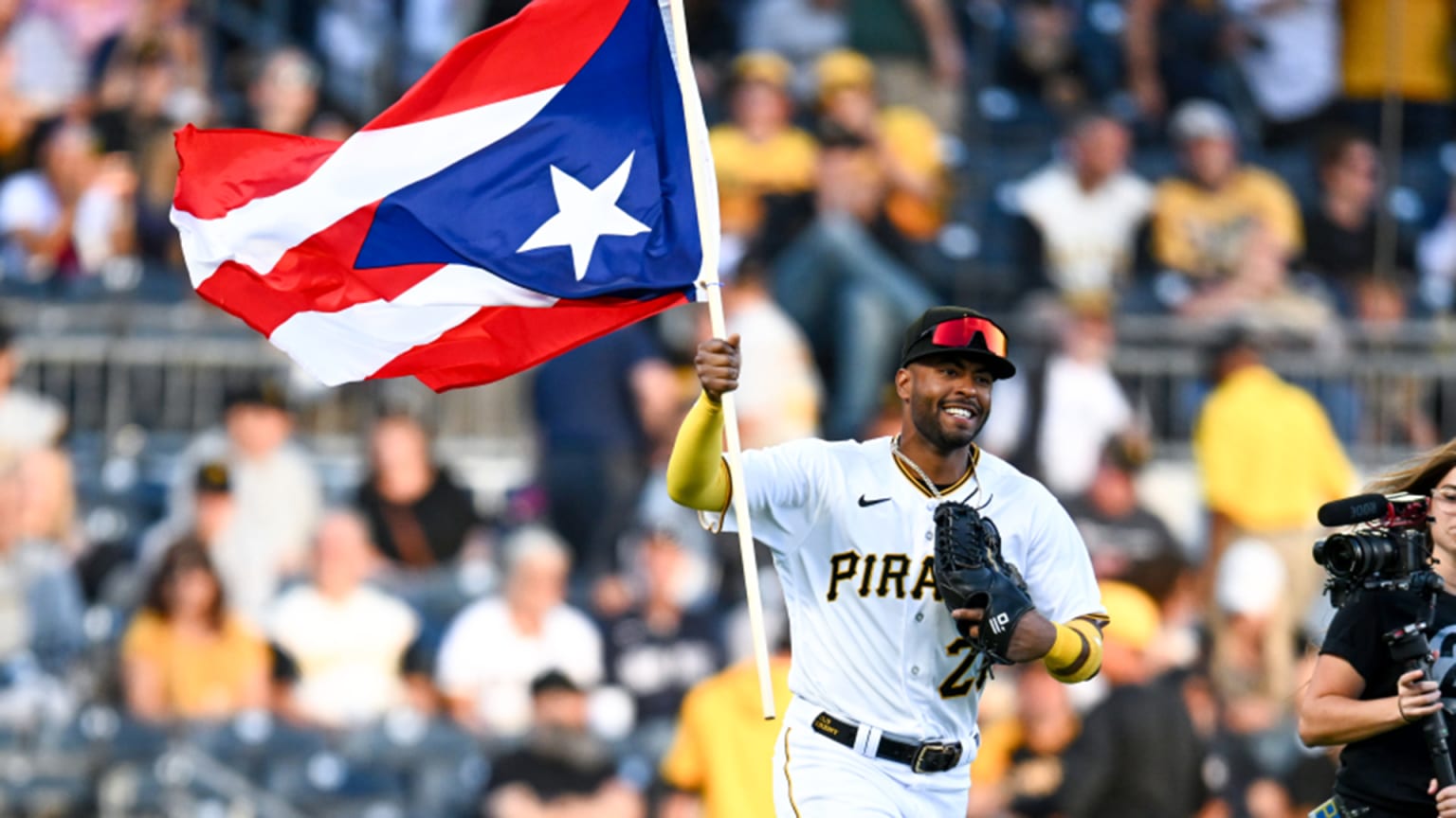 Joshua Palacios runs onto the field holding a Puerto Rico flag