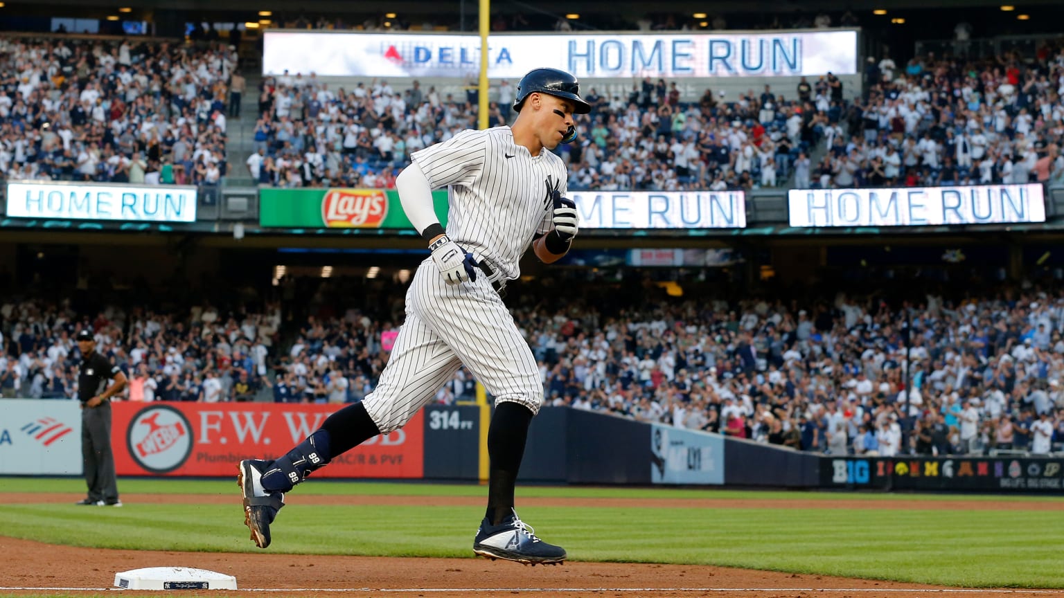 Aaron Judge rounds third base on a home run at Yankee Stadium, with ''HOME RUN'' on the video boards in the background