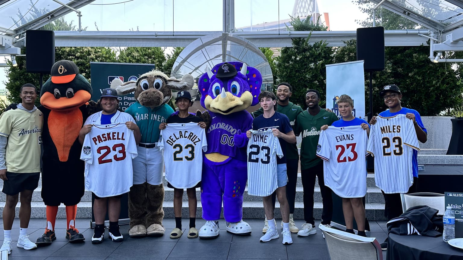 A group of fans pose for a photo with three mascots