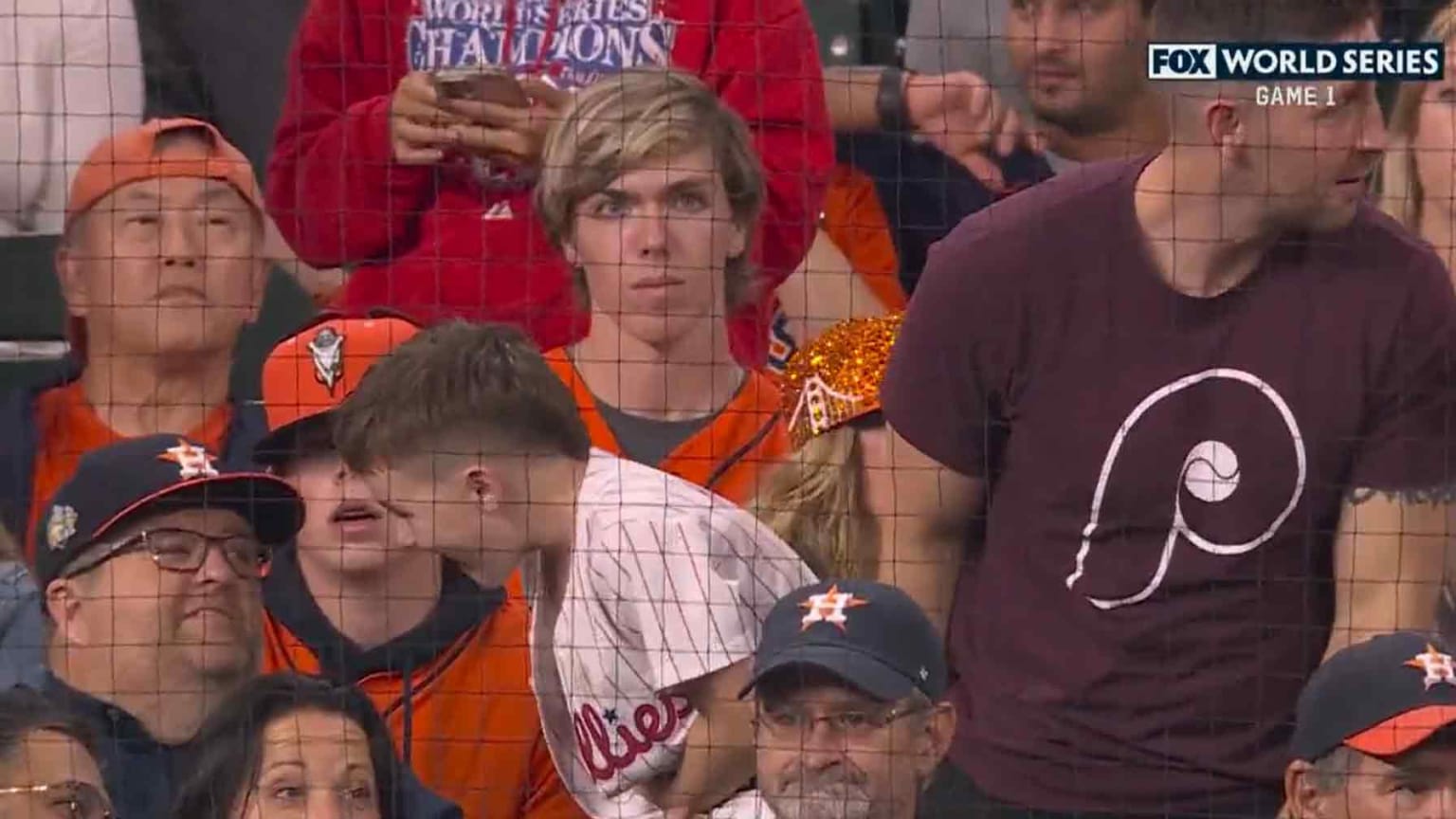 A young Phillies fan interacts with an older Astros fan