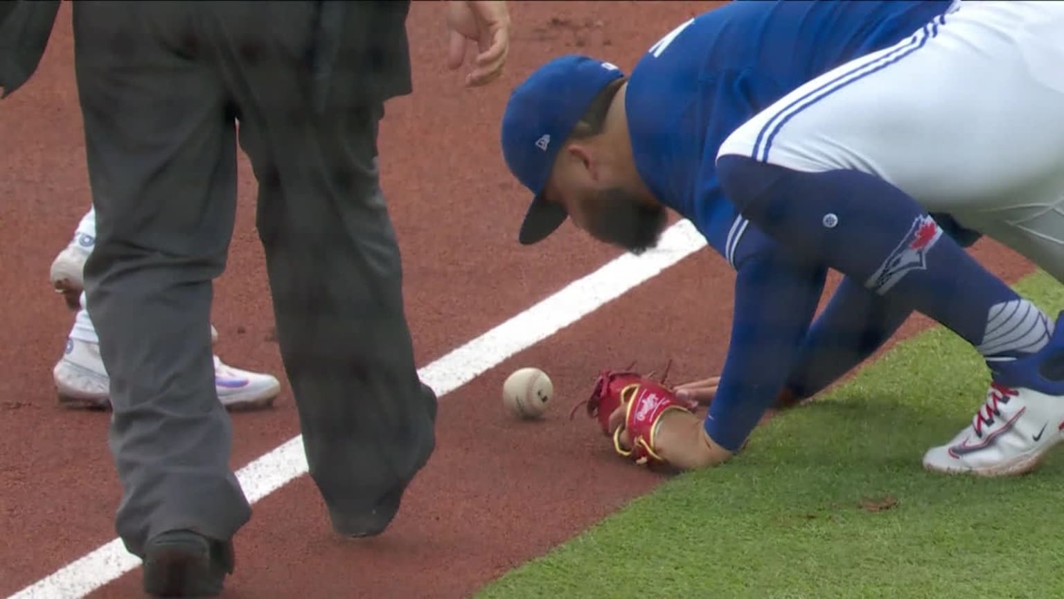 Alek Manoah attempts to blow a baseball into foul territory