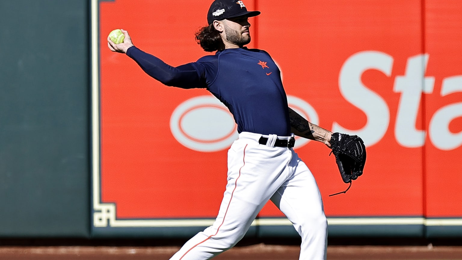 Astros pitcher Lance McCullers Jr. practices in front of an ad on the outfield wall