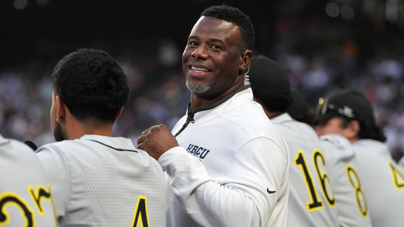 Ken Griffey Jr. smiles while surrounded by young players