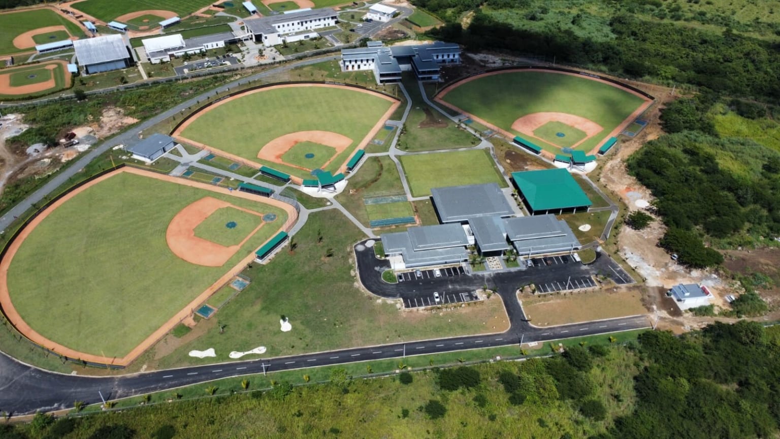An aerial view of three baseball fields and several buildings