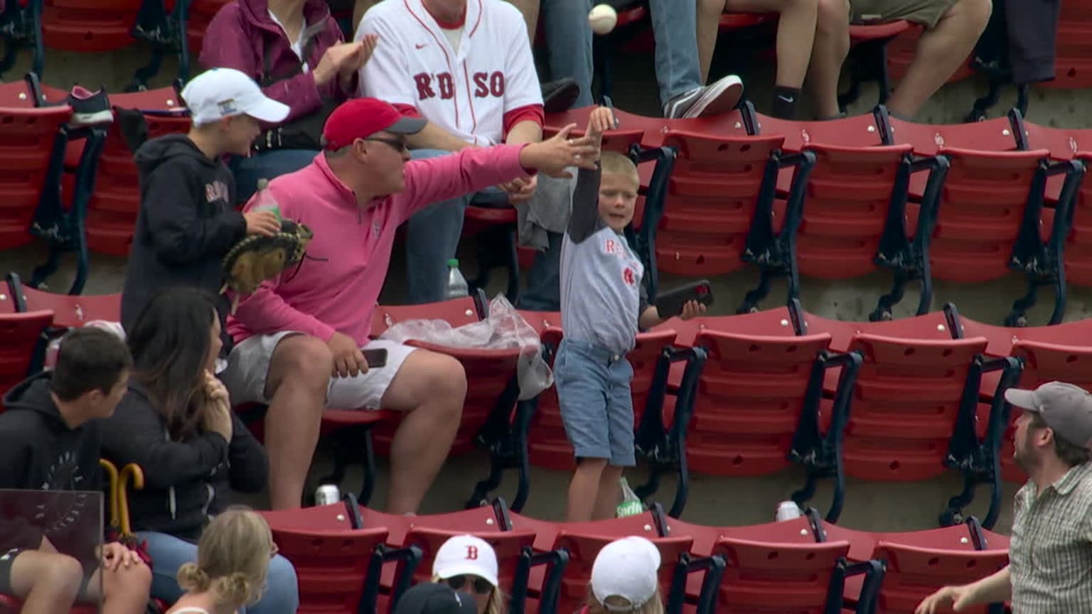 A young fan throws a baseball from the stands