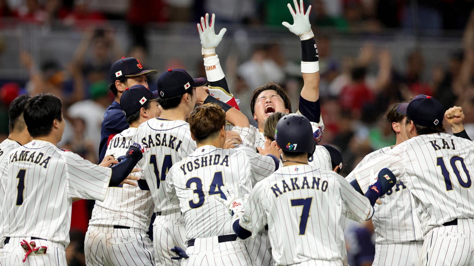 One player raises his arms to the sky amid a throng of celebrating teammates