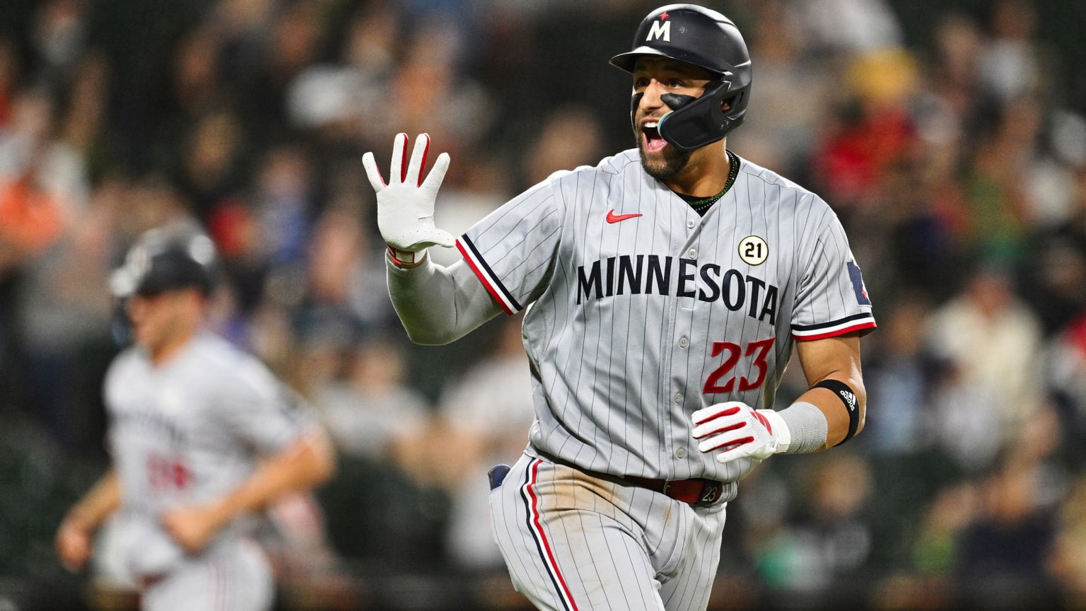 Royce Lewis flashes five fingers as he jogs to first base