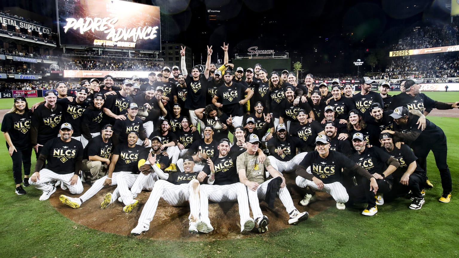 The Padres gather on the pitcher's mound in black shirts for a team photo