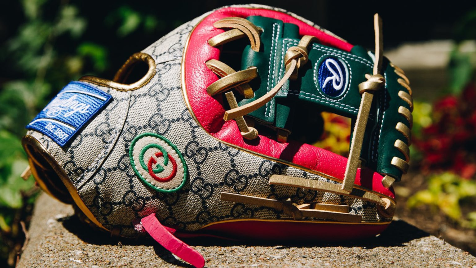 A green, red and tan Rawlings baseball glove featuring the iconic Gucci logo