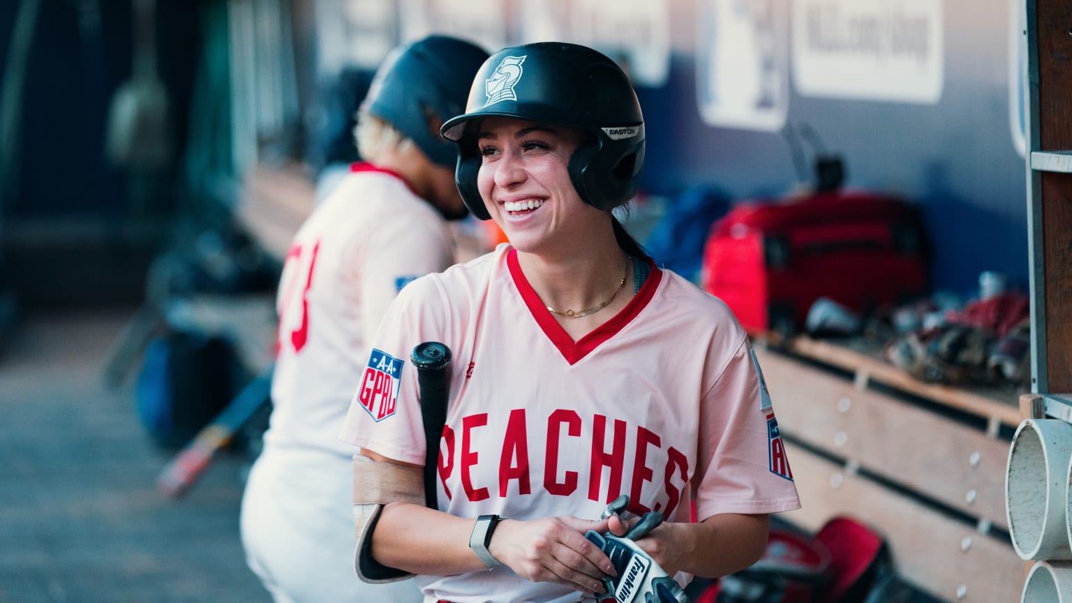 A player with a bat wearing a Rockford Peaches uniform