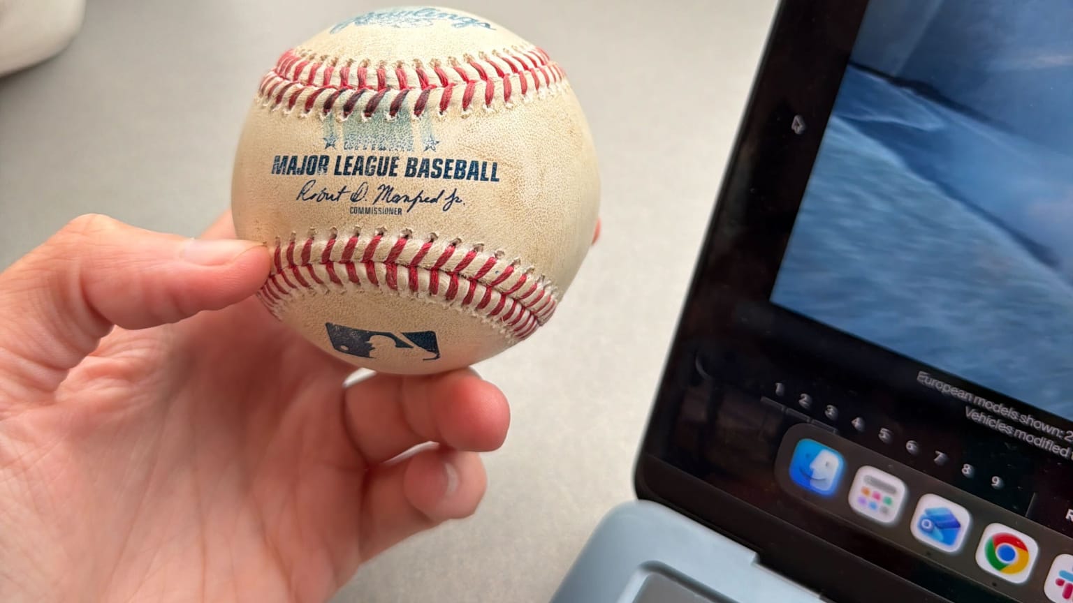 A reporter holds a foul ball in the press box
