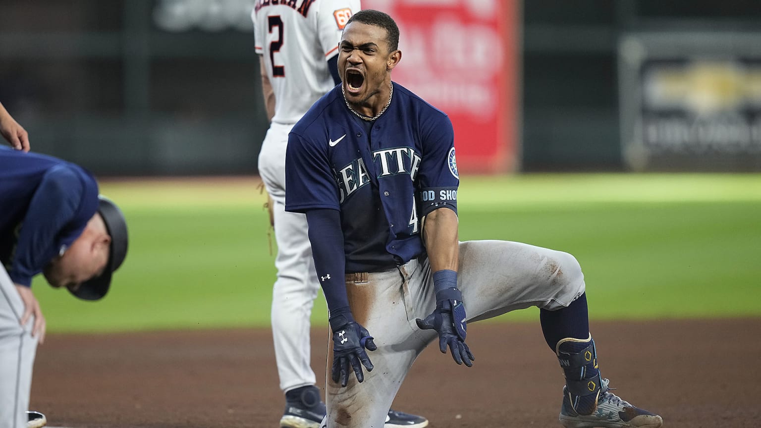 Mariners star Julio Rodriguez shouts while down on one knee after sliding into third base