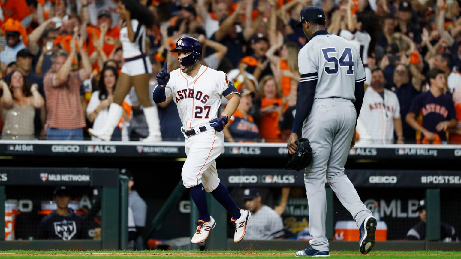 The Astros' Jose Altuve jogs home after hitting a home run as Yankees pitcher Aroldis Chapman walks off the field