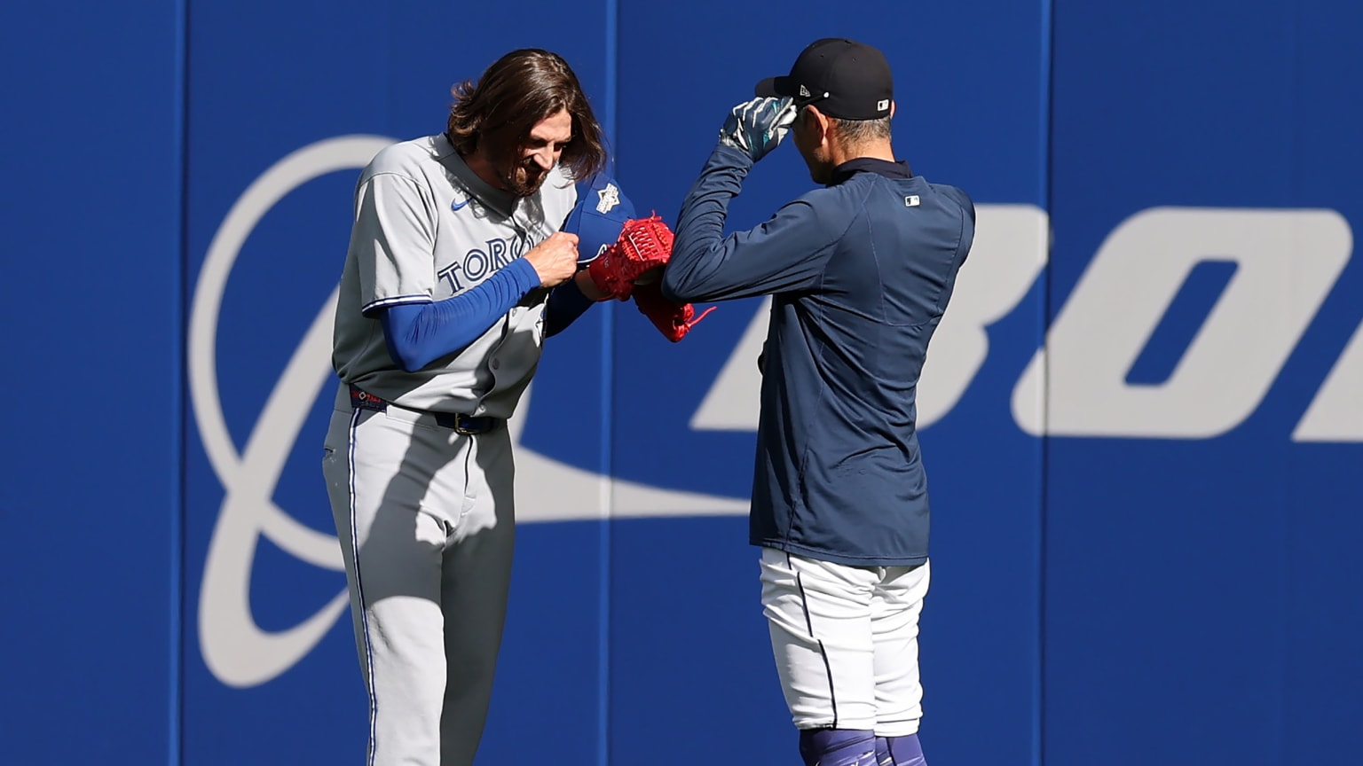 Blue Jays pitcher Kevin Gausman meets Ichiro Suzuki in the outfield before Game 3 of the ALCS