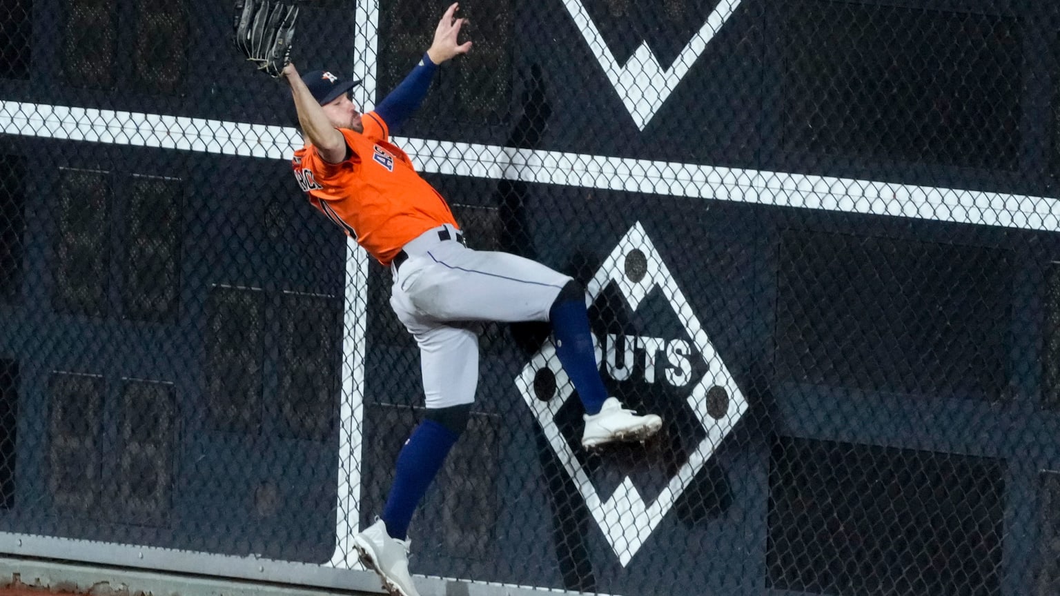 Chas McCormick falls backwards after making a leaping catch against the outfield fence