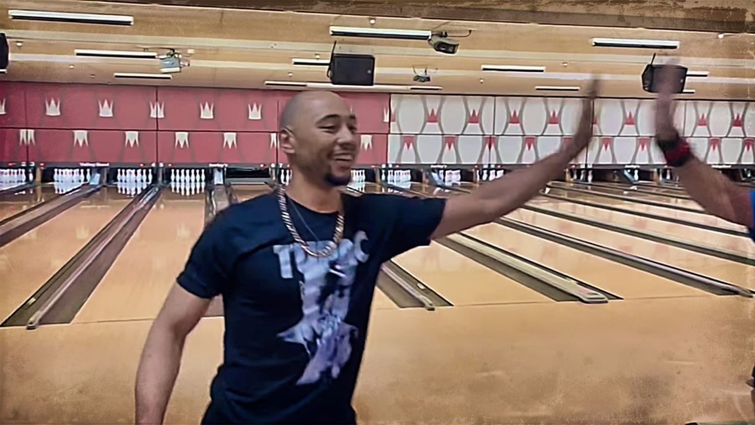 Mookie Betts high-fives a person at a bowling alley