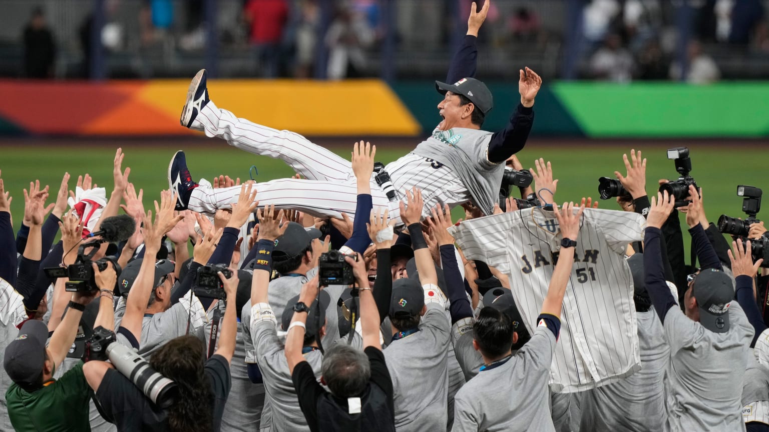 Team Japan tosses its manager into the air