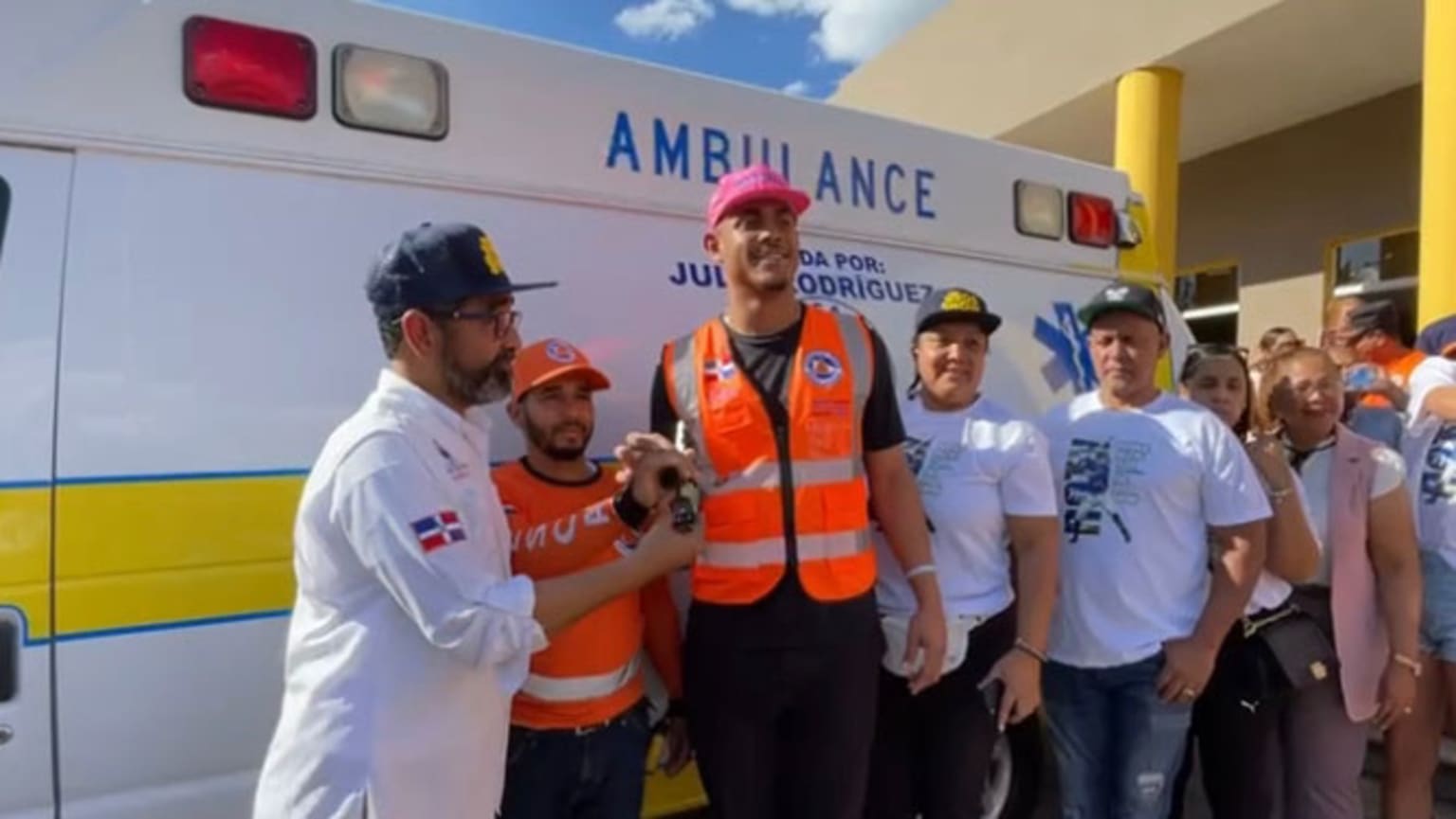Julio Rodríguez poses with people in front of an ambulance