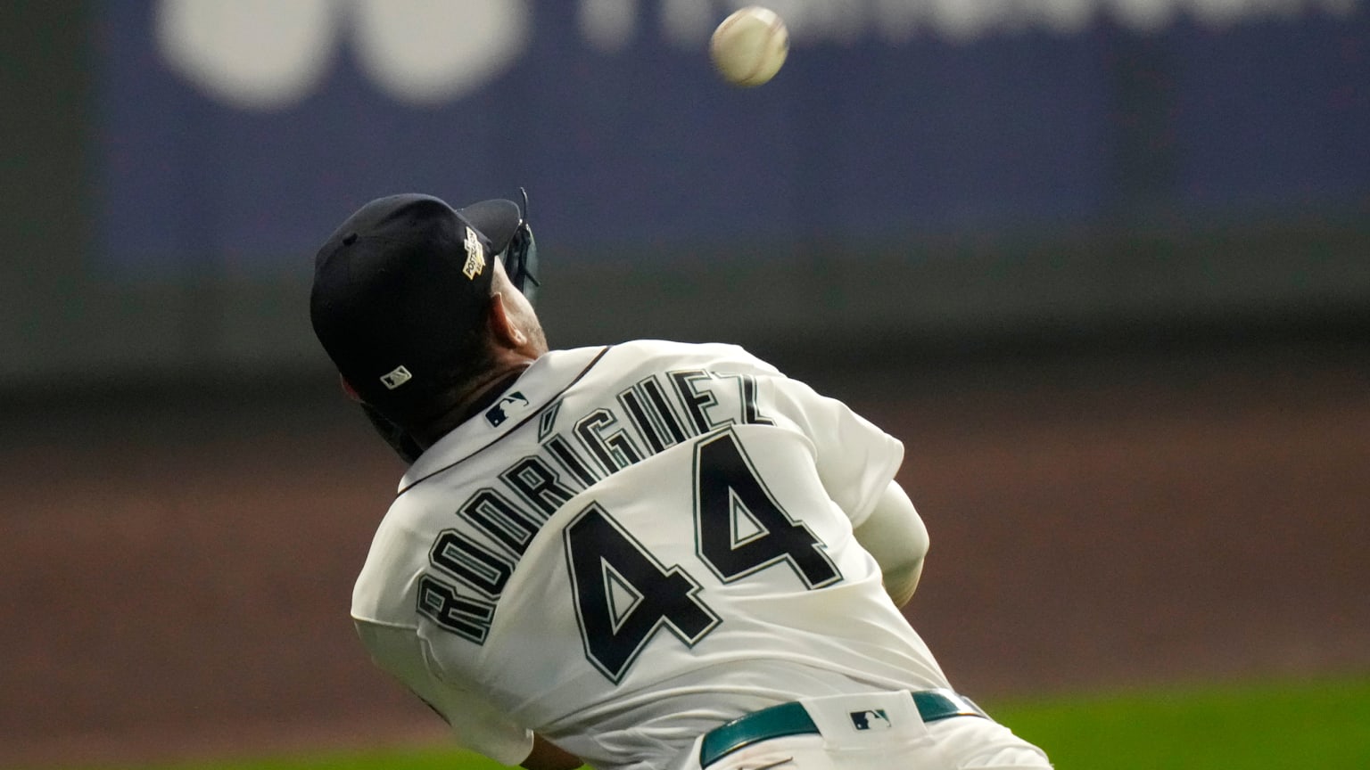 A view of a player from the back, ''RODRIGUEZ'' on his jersey and the number 44, as a ball nears his glove