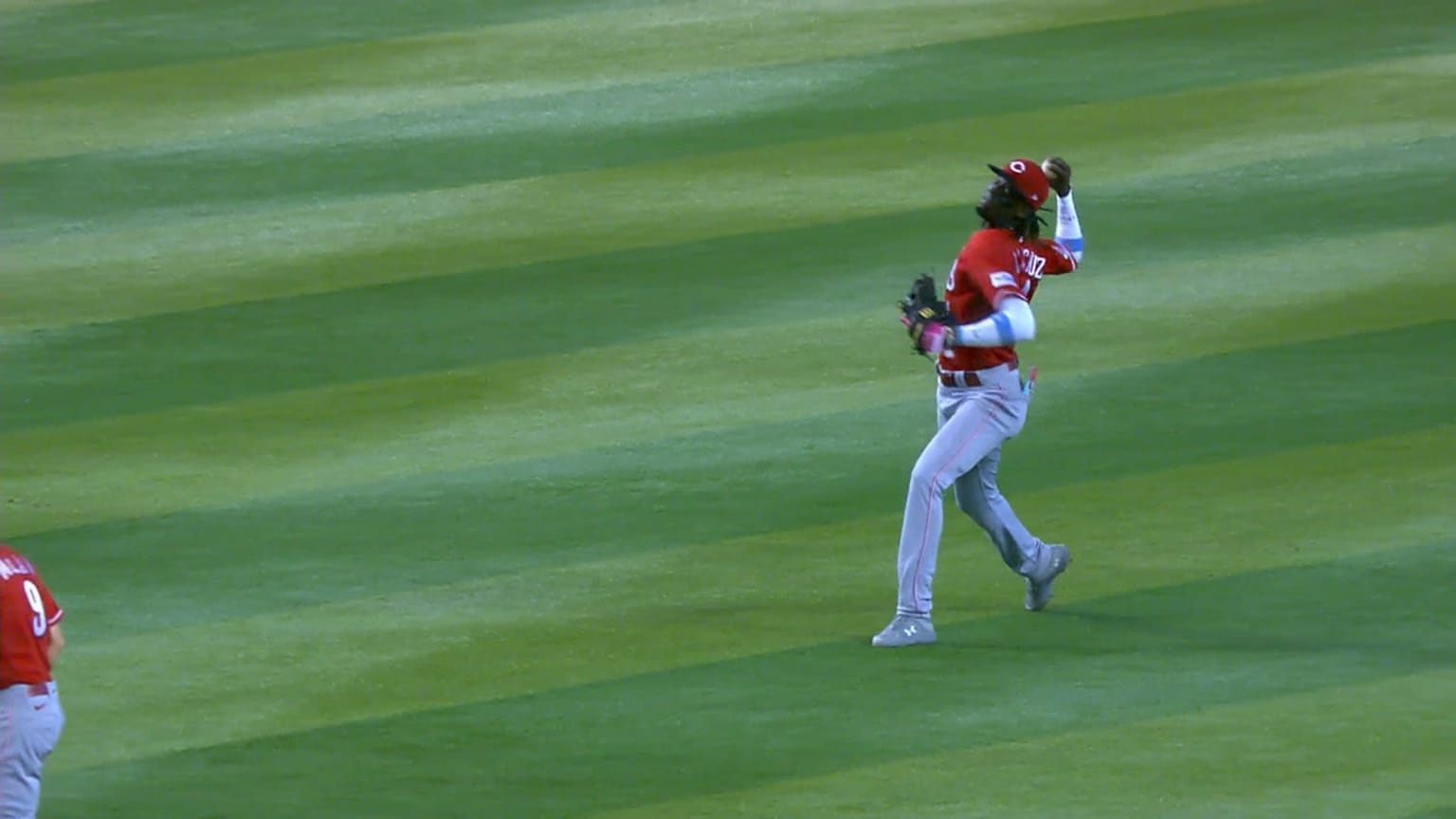 Elly De La Cruz throws from the outfield grass