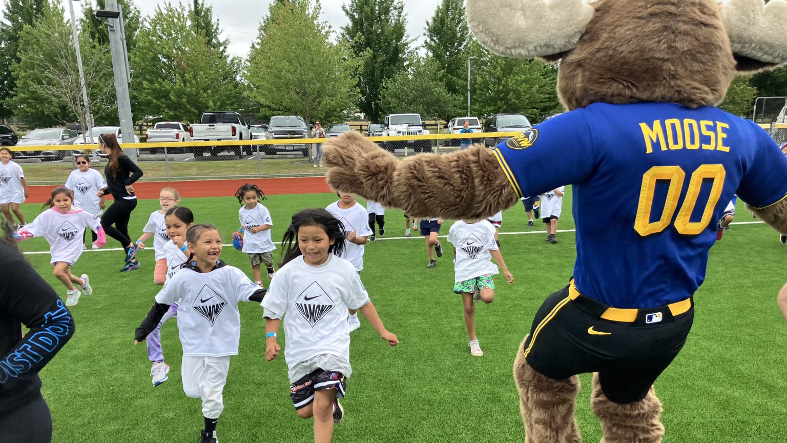 Children run and play with the Mariners mascot
