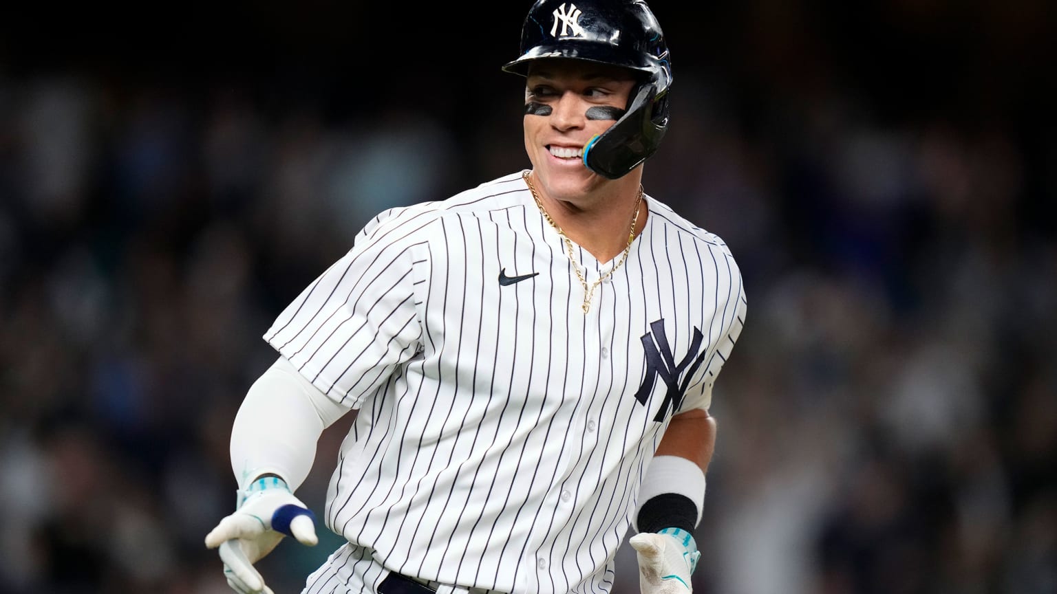 Aaron Judge smiles and points as he rounds the bases