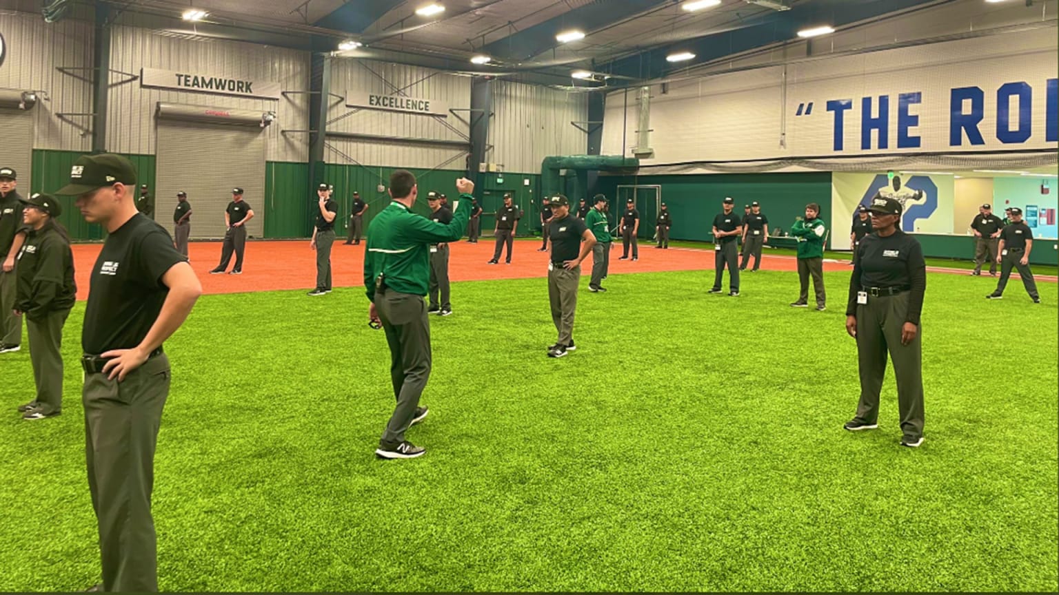 Umpires in training are spread out on an indoor field