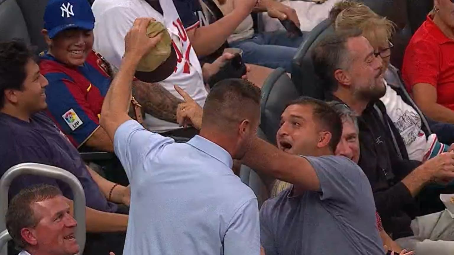 Two fans celebrate after both took part in catching a foul ball at Target Field