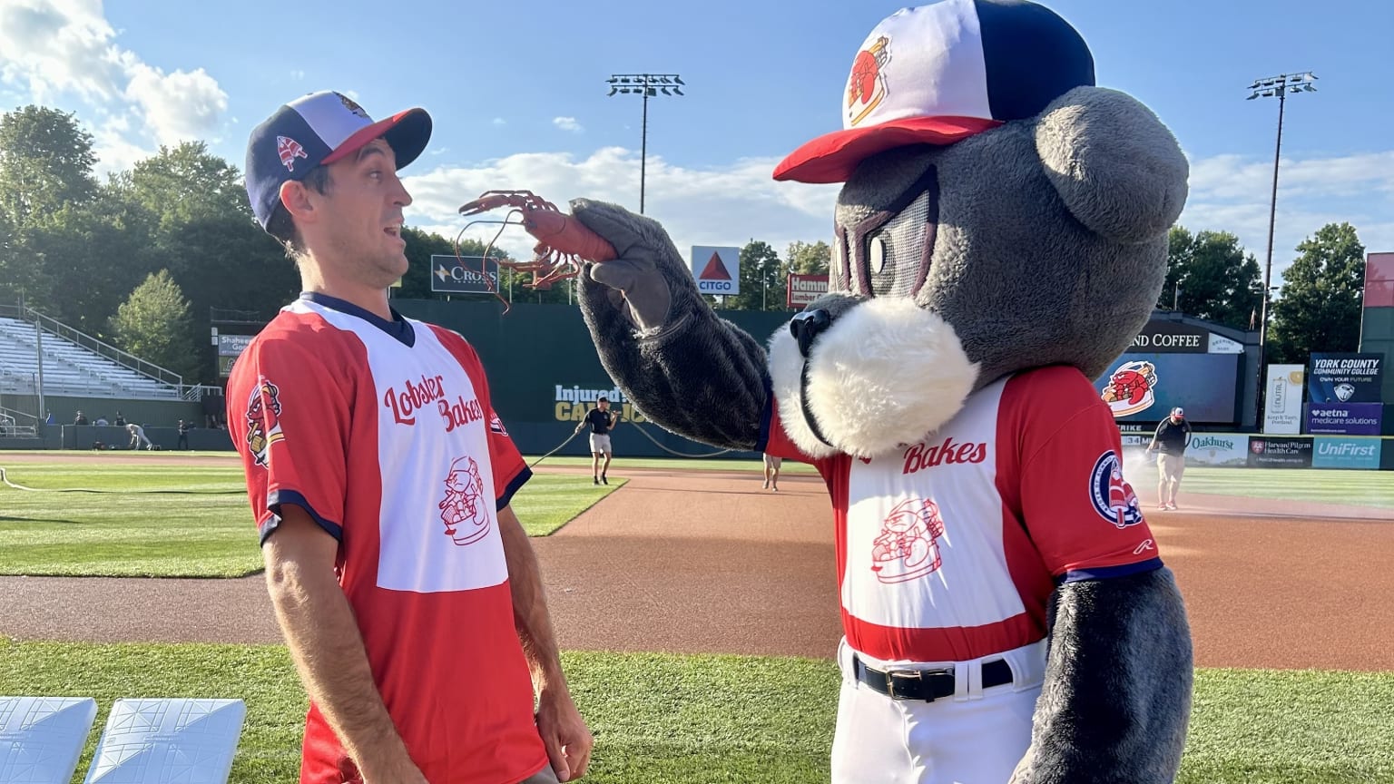 Portland mascot Slugger the Sea Dog brandishes a lobster in the face of lobsterman/influencer Jacob Knowles