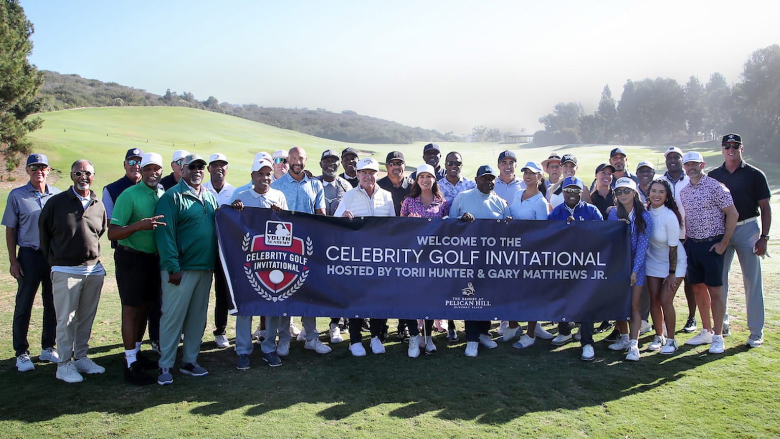 Golfers pose with a banner for the Celebrity Golf Invitational