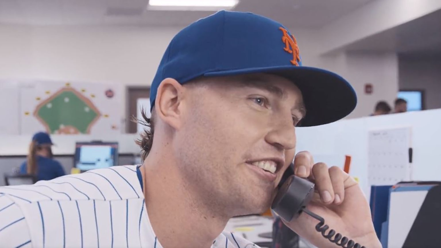 Brandon Nimmo, in uniform, on the phone in an office