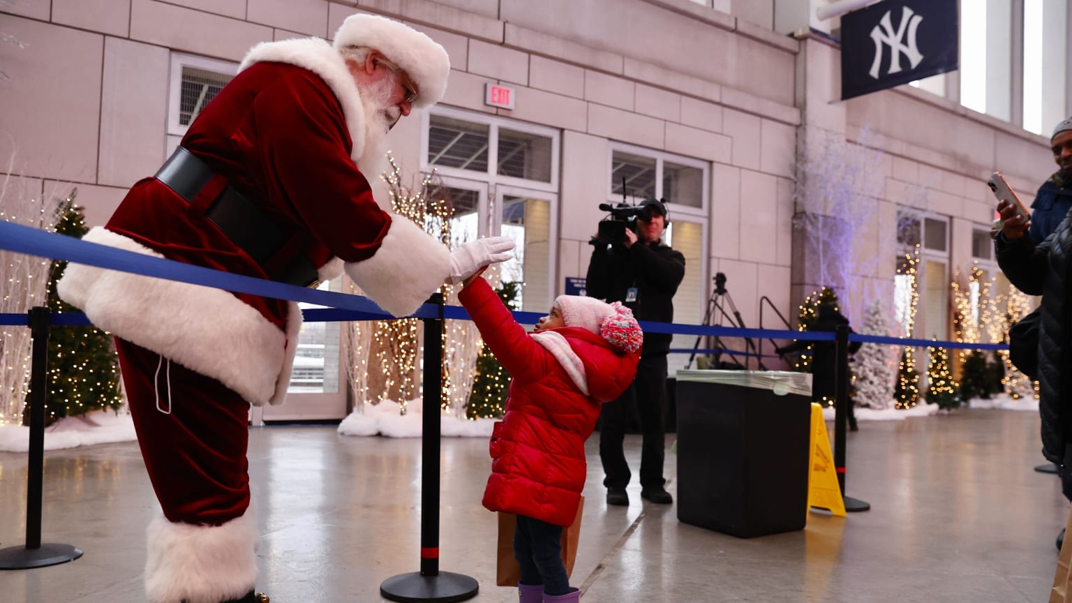 Santa Claus high-fives a child on the concourse at Yankee Stadium