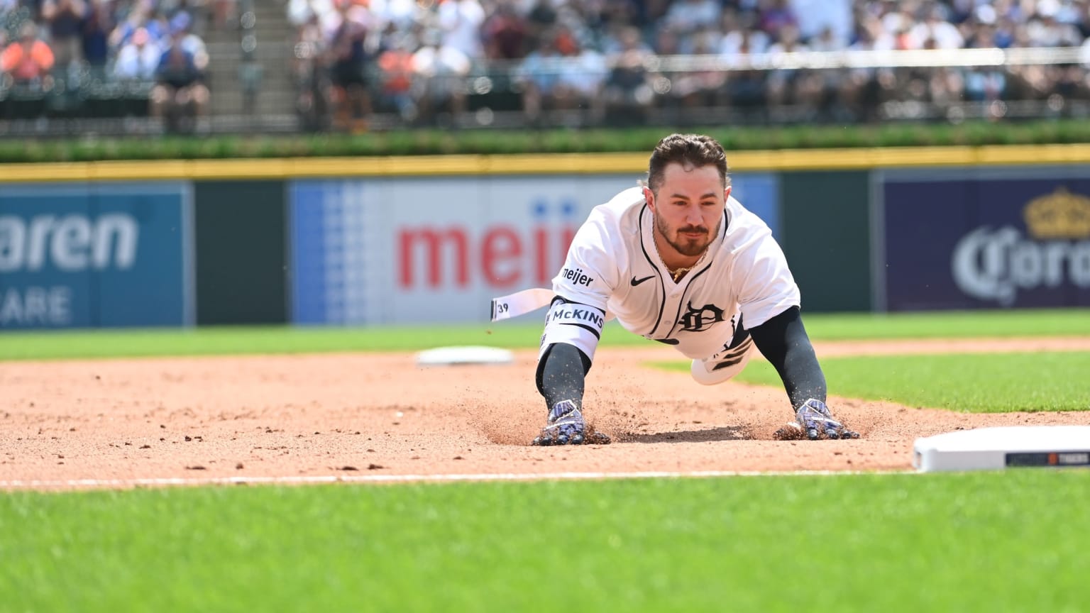 The Tigers' Zach McKinstry sliding head-first into third base