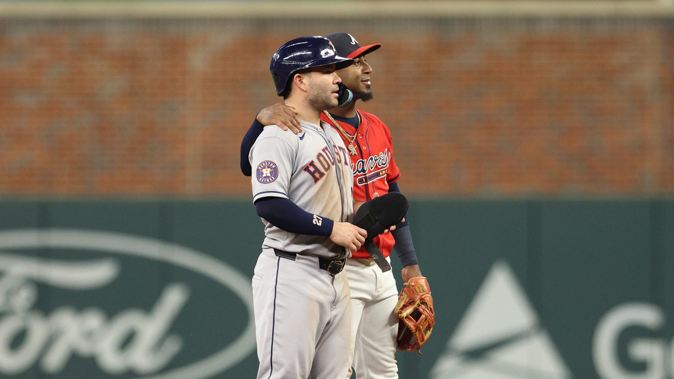 Braves second baseman Ozzie Albies puts his arm around the Astros' Jose Altuve