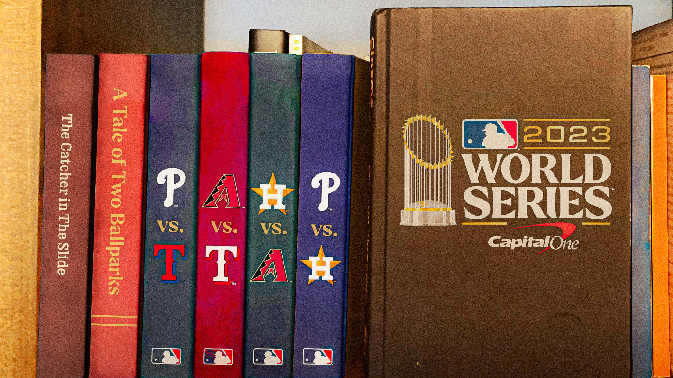 A photo illustration of books on a bookshelf, the last one featuring the World Series logo on its cover