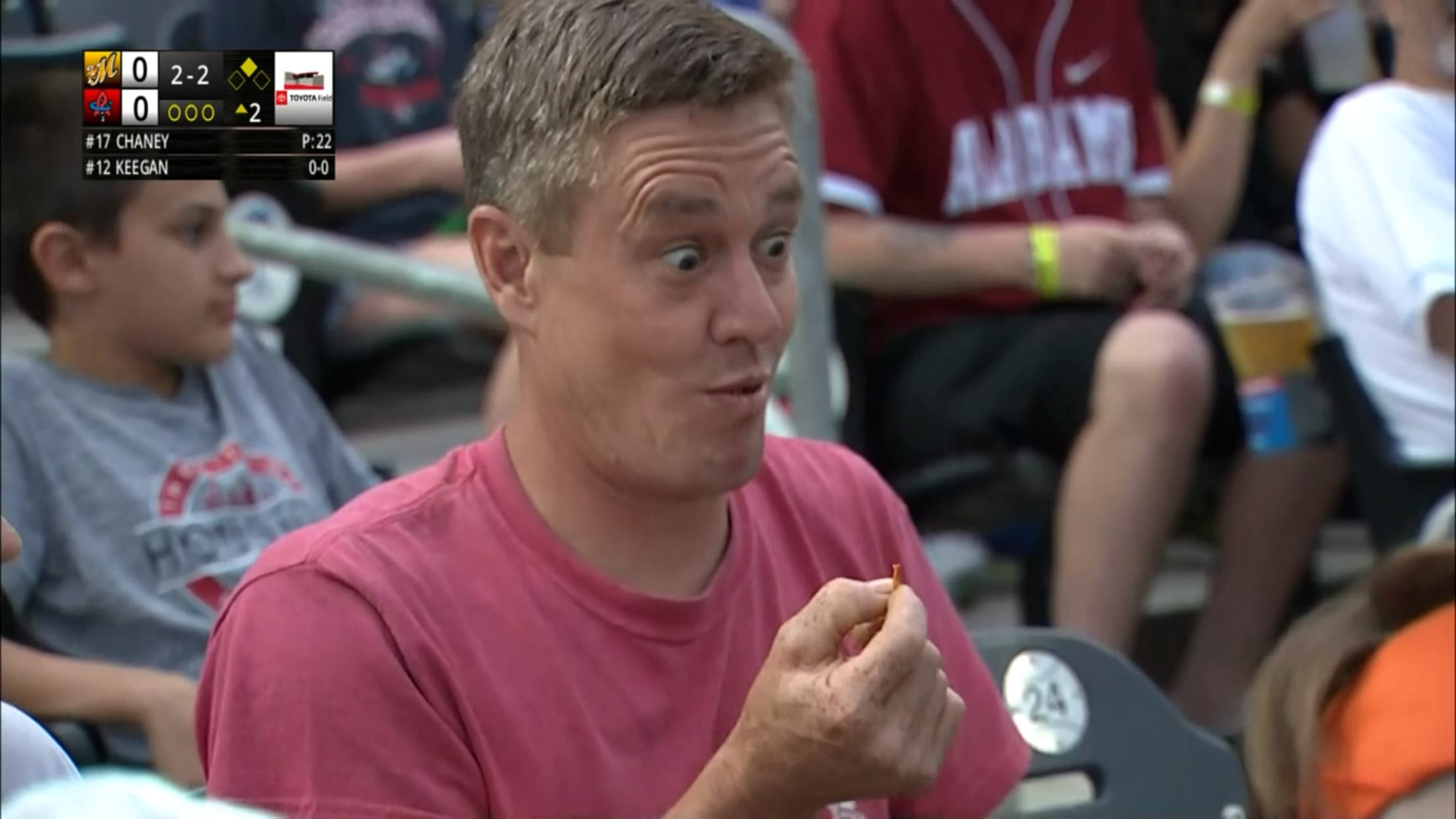 A fan reacts after eating a cicada at a Minor League game