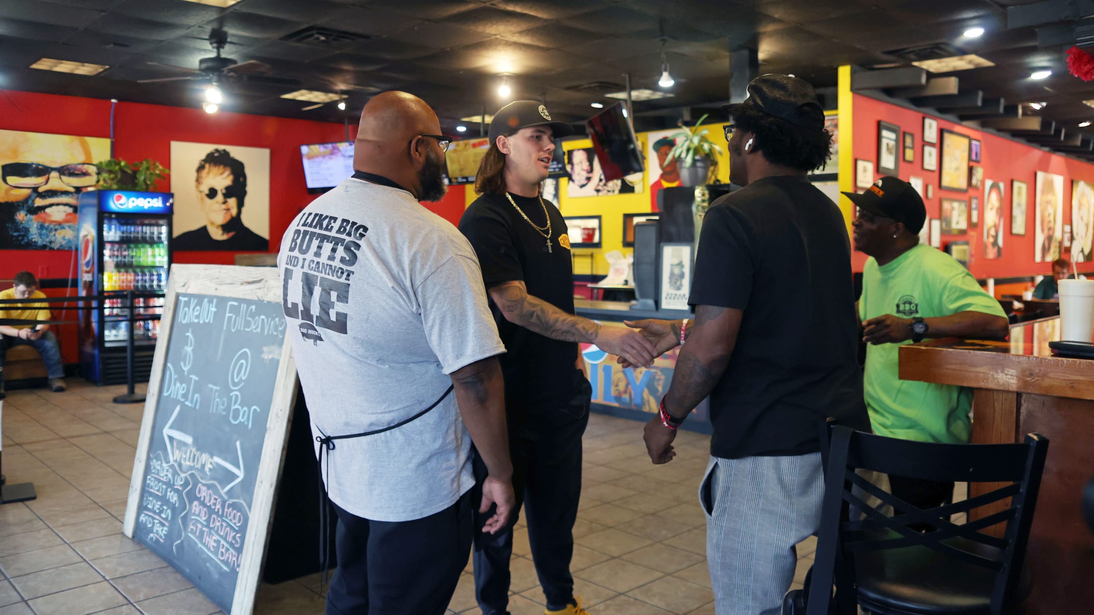Hall shaking hands with a resident of Valdosta while going to lunch at Big Nick's.