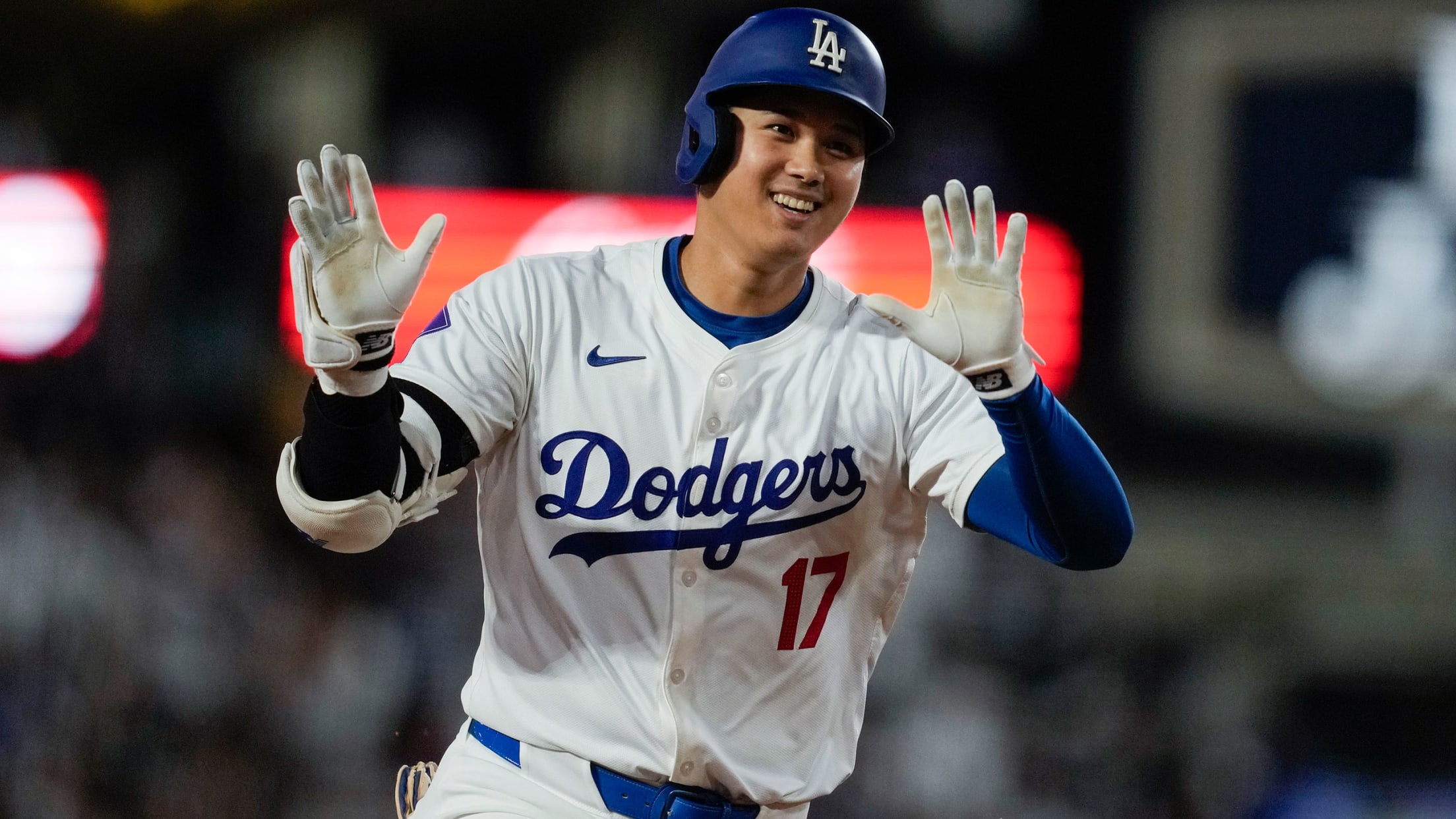 Shohei Ohtani waves his hands at the Dodgers' dugout as he rounds third in his home run trot