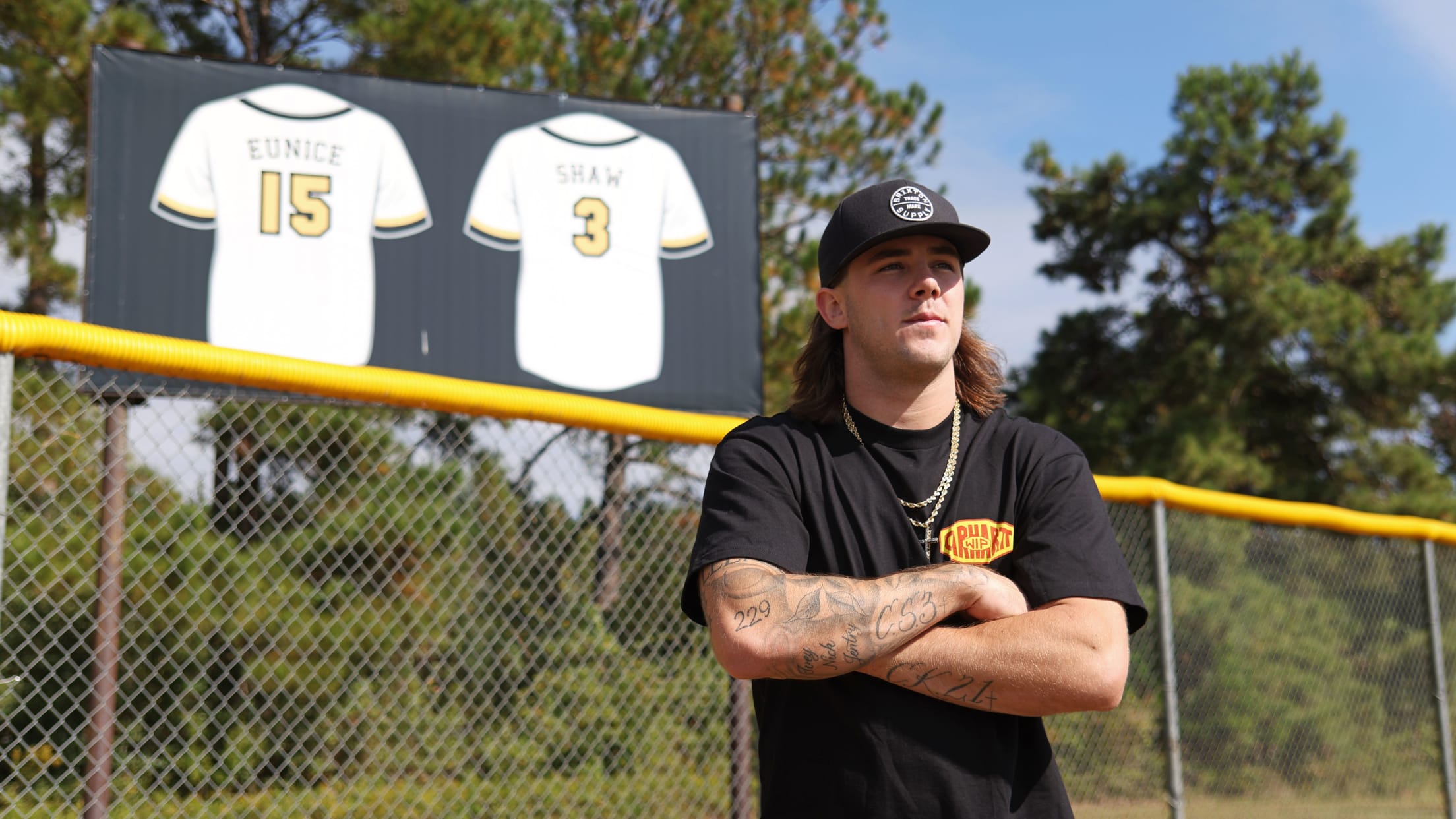 Hall posing with the two retired jerseys for the Valdosta Wildcat baseball team.  Shaw, number 3, died during Hall's sophomore season.  CS3 is tattooed on Hall's forearm in remembrance of his teammate.