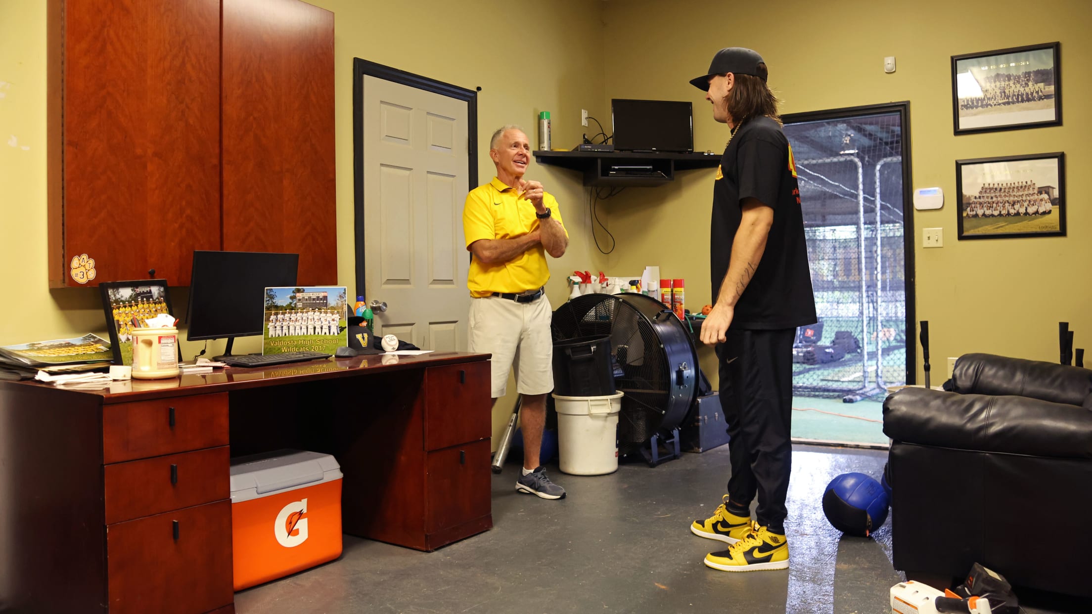 Hall chatting with former high school coach Bart Shuman in the Valdosta baseball coaching office.