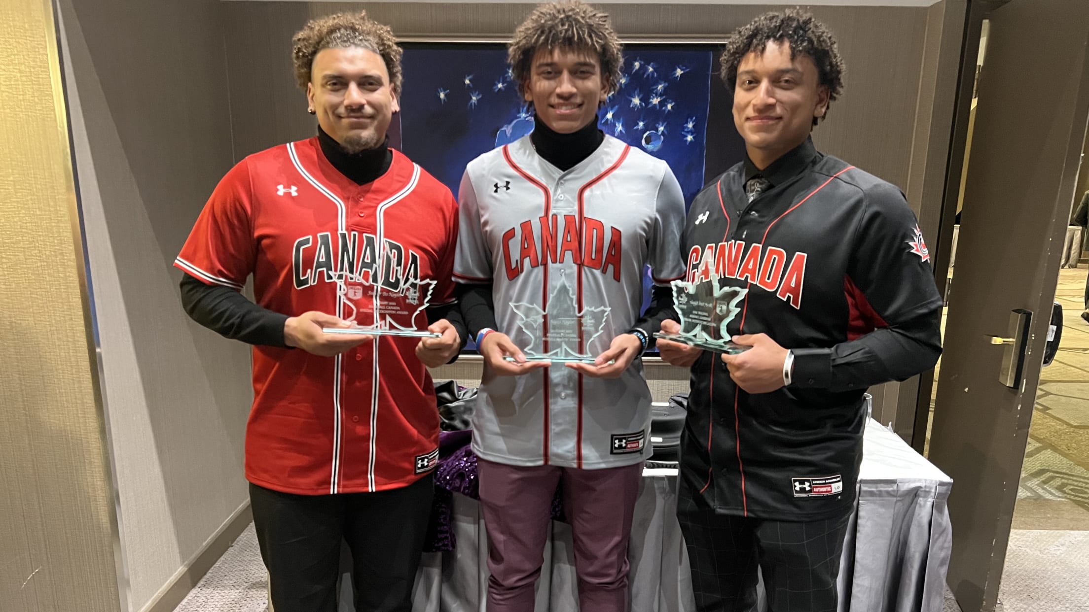 The three Naylor brothers pose in Canada jerseys holding awards