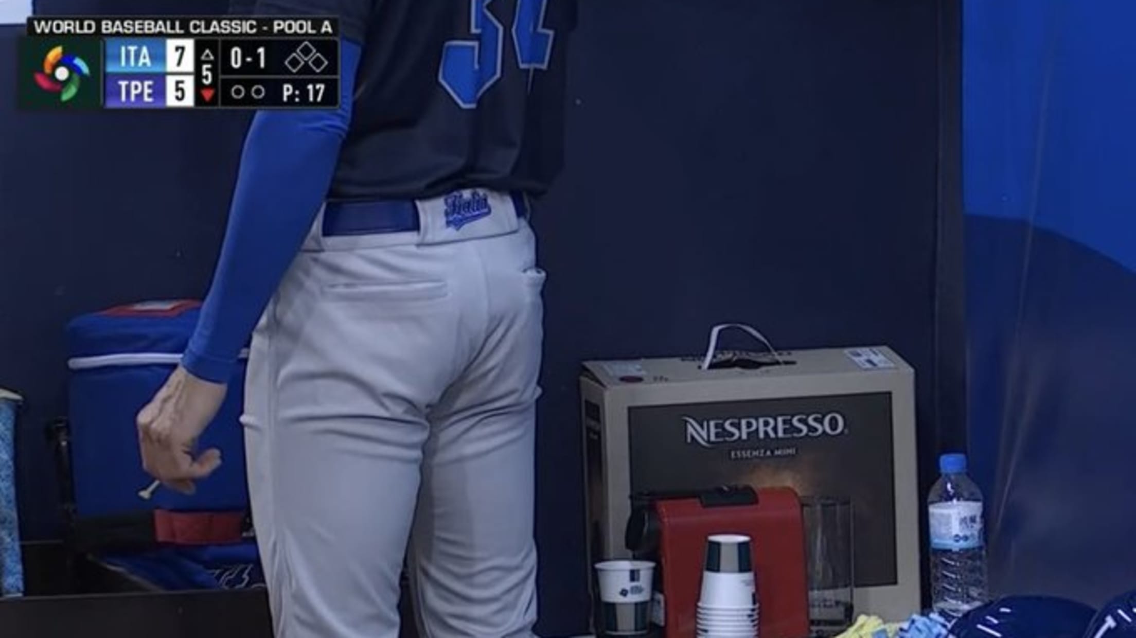 A video screengrab showing a player in a dugout standing next to a Nespresso box and machine