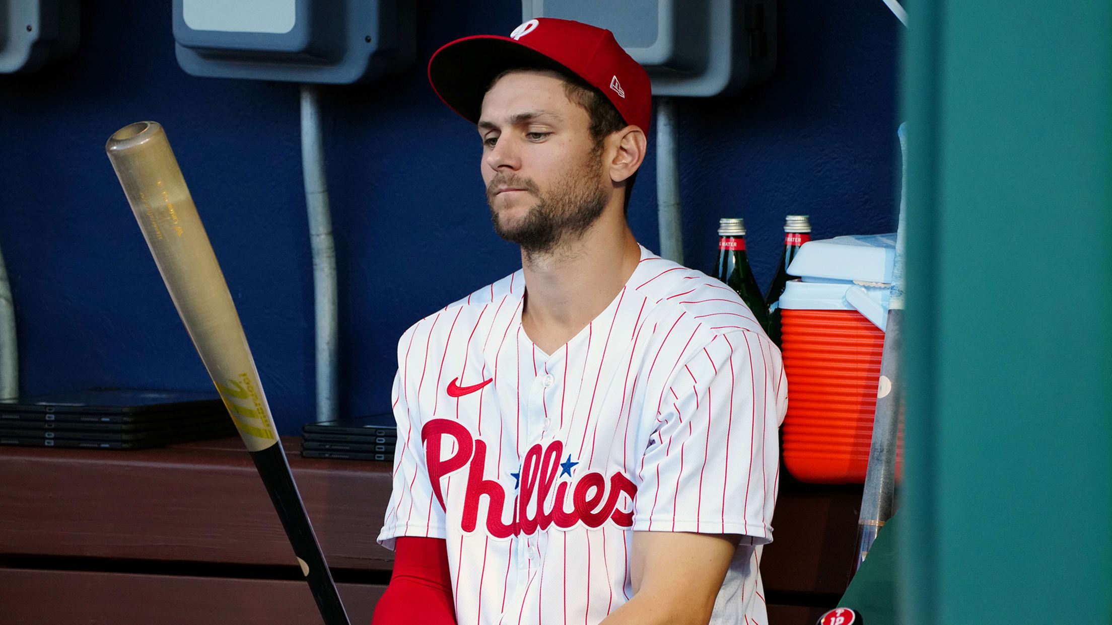 Trea Turner looks at a bat in the dugout