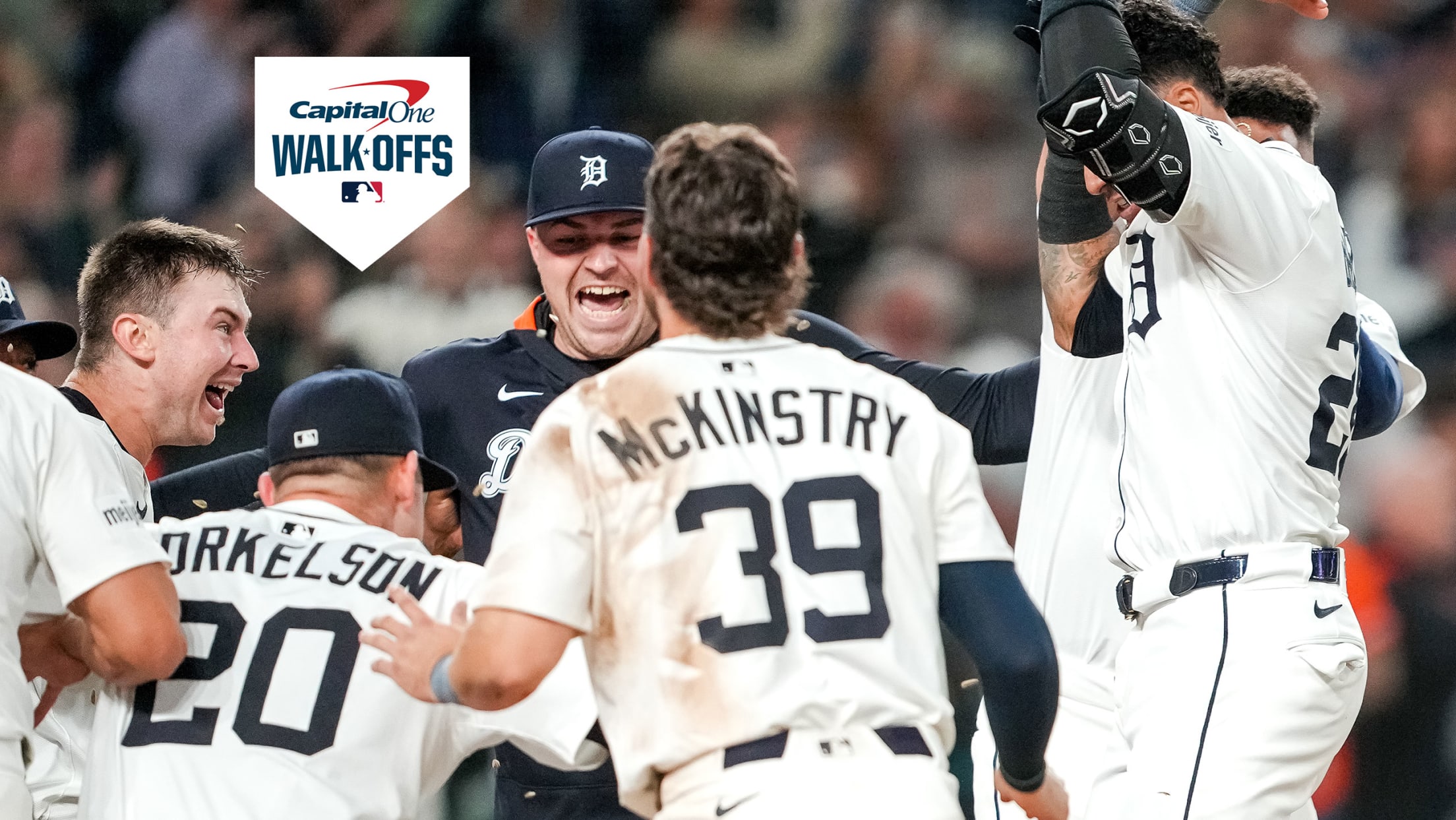 Javier Báez leaps on home plate amid a group of celebrating teammates