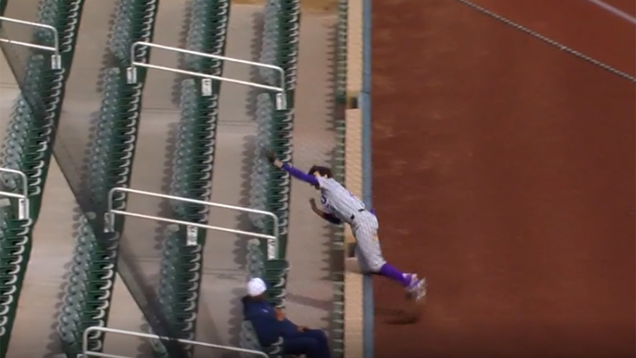 A video screengrab of a player falling over a wall in foul territory