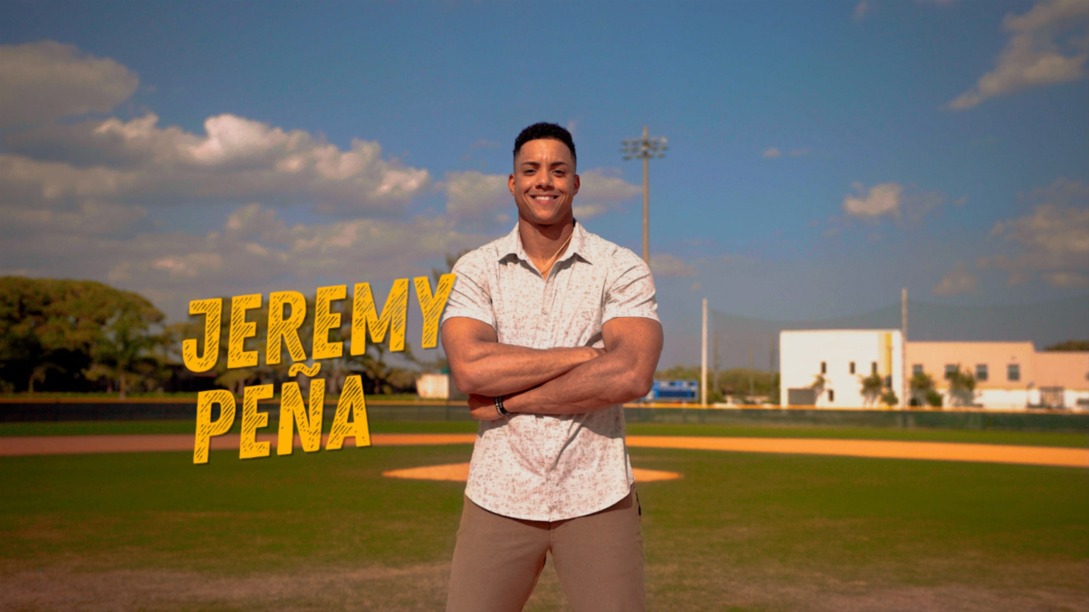 Jeremy Peña stands on a baseball field with his arms crossed