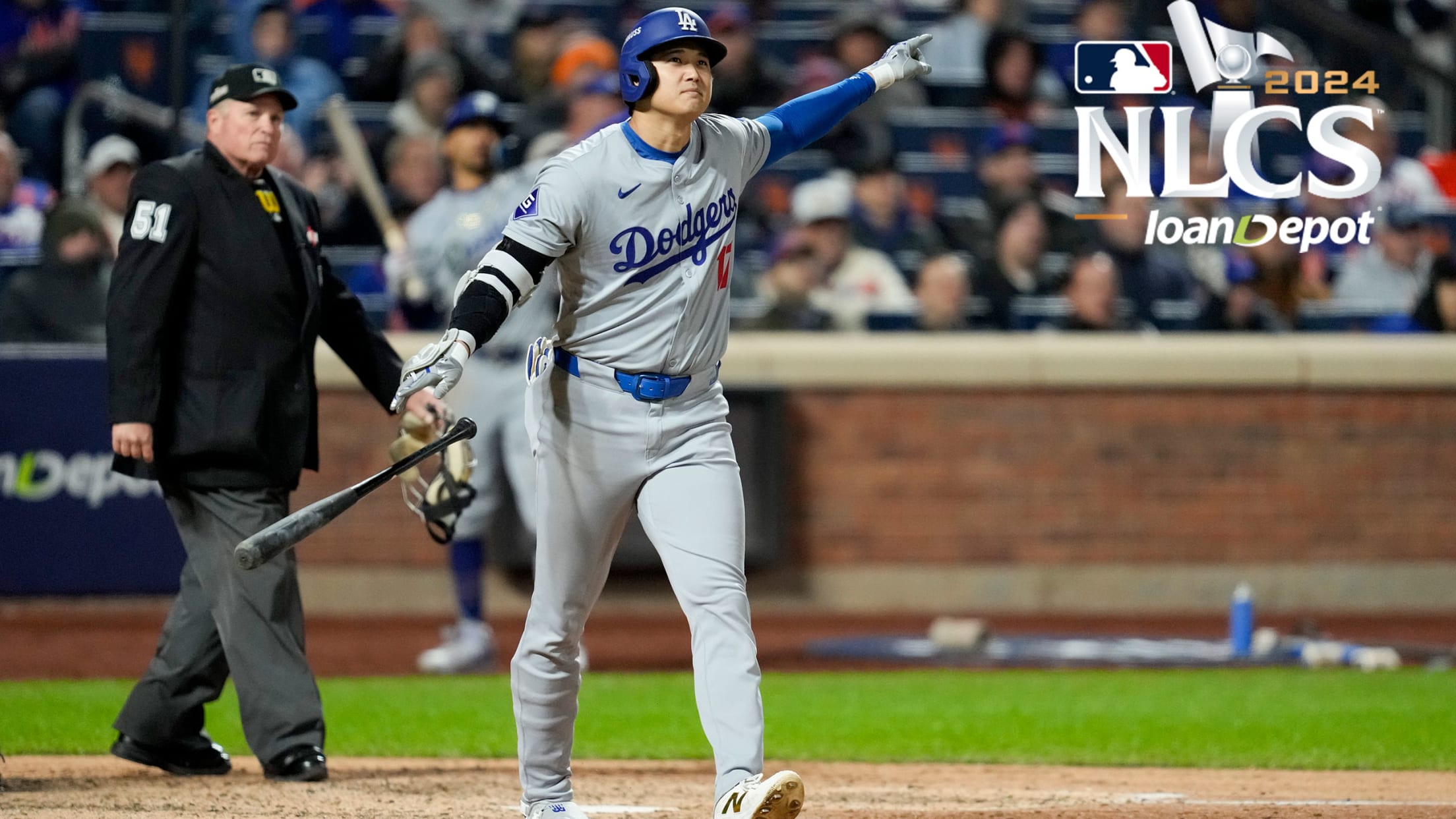 Shohei Ohtani points to the Dodgers dugout as he watches his home run