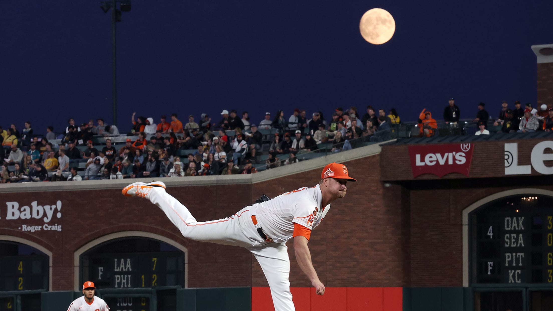 Alex Cobb follows through on a pitch with a full moon hanging over the ballpark