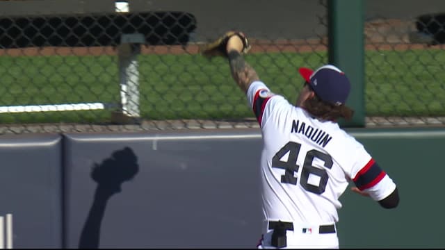 Cincinnati Reds center fielder Tyler Naquin, front, lies on the