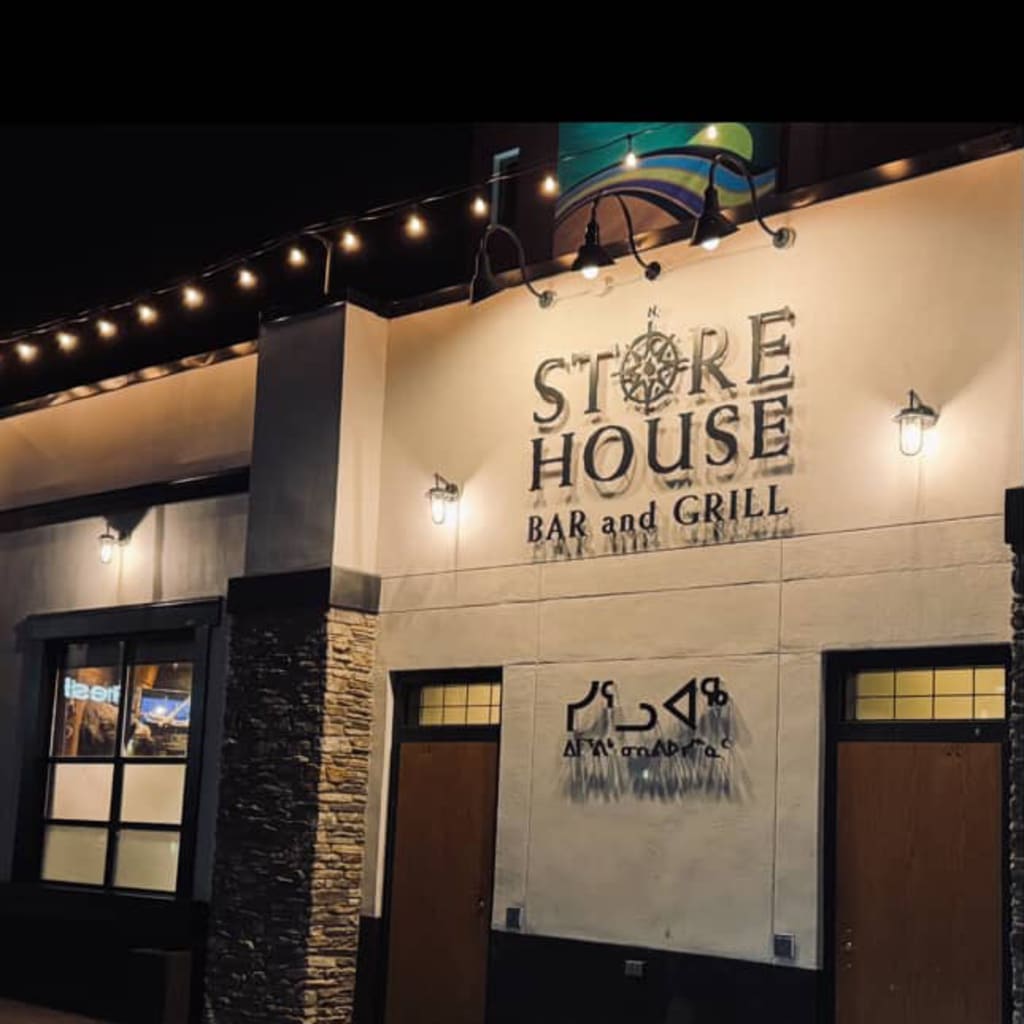 The front of Storehouse, with English and Inuktitut lettering